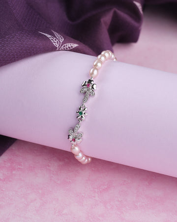 Chandrani Pearls’ Trendy Metallic CZ Pretty Bracelet: A chic bracelet with metallic and CZ details, displayed on a rolled white surface and complemented by soft purple fabric in the background.