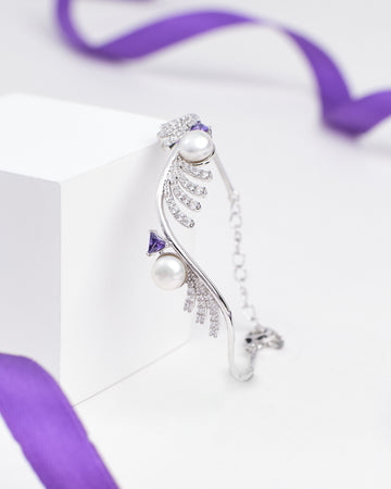 The Chandrani Pearls Luxury Tennis Bracelet in Sterling Silver with CZ Stones is showcased on a white block, accented by a purple ribbon in the background.