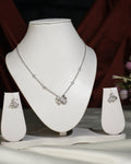 The Cute Pendant Set by Chandrani Pearls India, featuring a necklace and matching butterfly-shaped earrings displayed on stands, radiates graceful elegance against contrasting backgrounds.