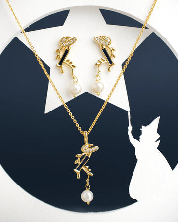 Krishna flute Pearl Pendant Sets by Chandrani Pearls India featuring gold necklaces and earrings with pearl and rhinestone accents are displayed in front of a star and witch silhouette backdrop.