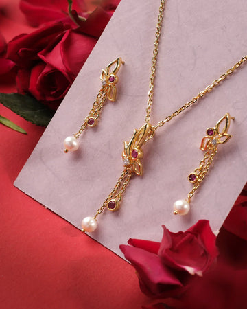 Kusum Leafy 925 Silver Pendant Set by Chandrani Pearls India, adorned with pearl drops and red gemstones, elegantly displayed on a light board with red roses.