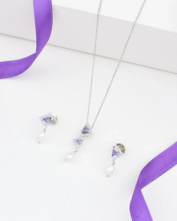 The Demifine Classic Pearl Pendant Set 925 Silver with CZ Accents by Chandrani Pearls features a pearl pendant and matching earrings, displayed on a white surface with purple ribbon accents.