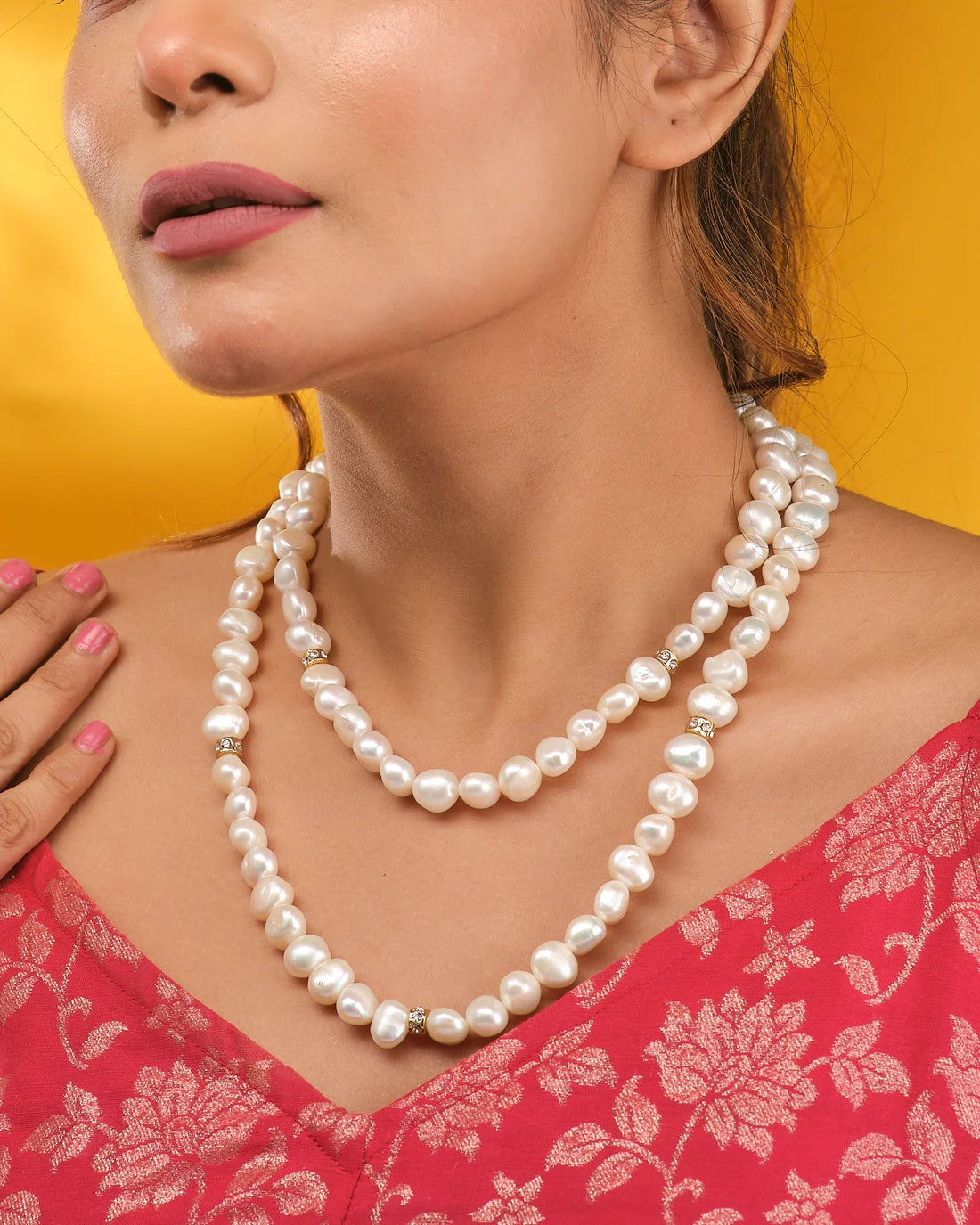The Un-even Shaped Pearl Lariat with CZ Charm by Chandrani Pearls is showcased on a dark blue velvet bust with cream fabric accents—an elegant evening jewelry piece.
