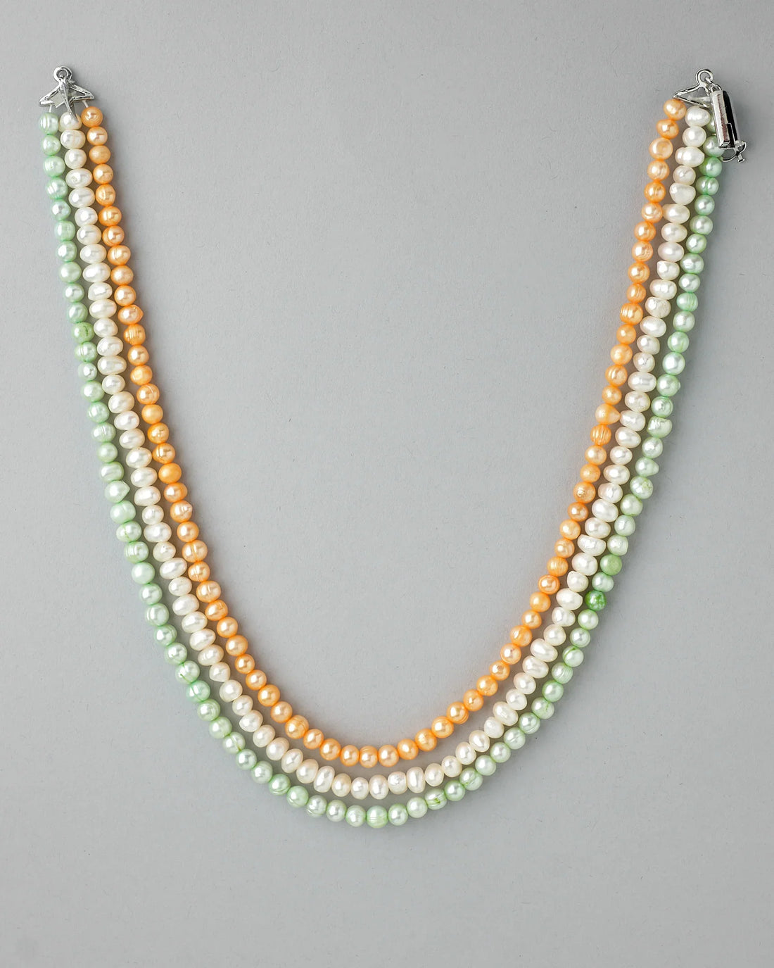 A woman wears Chandrani Pearls' Elegant Patriotism Limited Edition Pearl Necklace in white, peach, and green with a "Patience is" tattoo and an arrow on her collarbone—a standout among women's accessories.