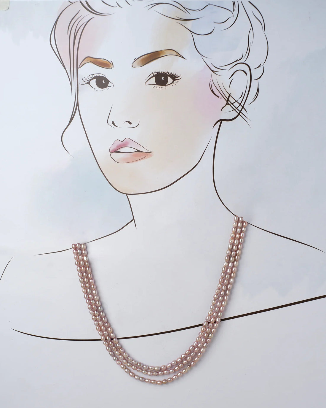 The Udagat - Blushing Rose Pearl Necklace by Chandrani Pearls is elegantly draped over a purple cylinder on a soft pink surface.
