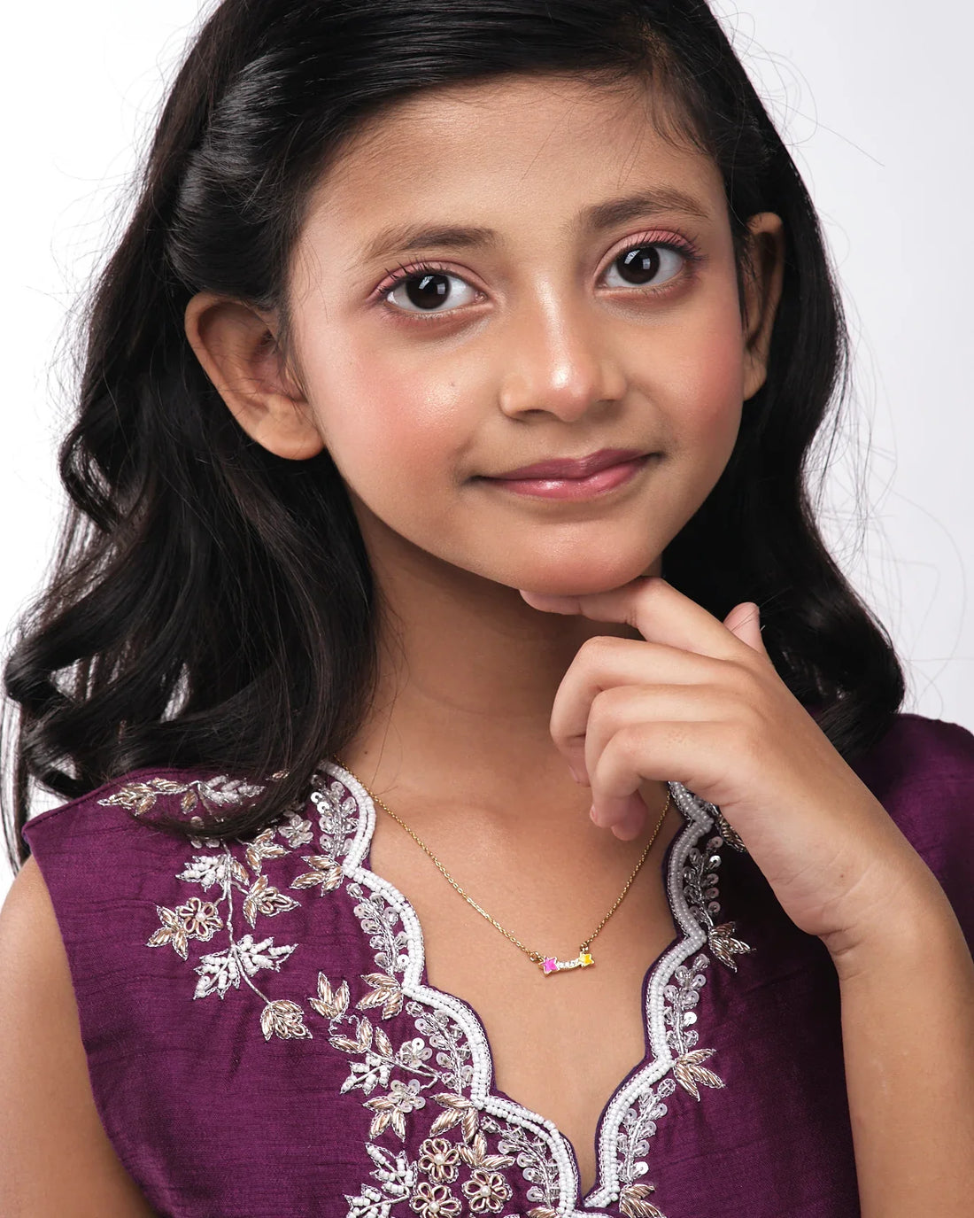 The Dual Star Beautiful Pendant by Chandrani Pearls India is a gold necklace featuring two central stars—one pink, one yellow—linked by clear stones, with a silhouette of a figure holding a wand with a star cutout in the background.