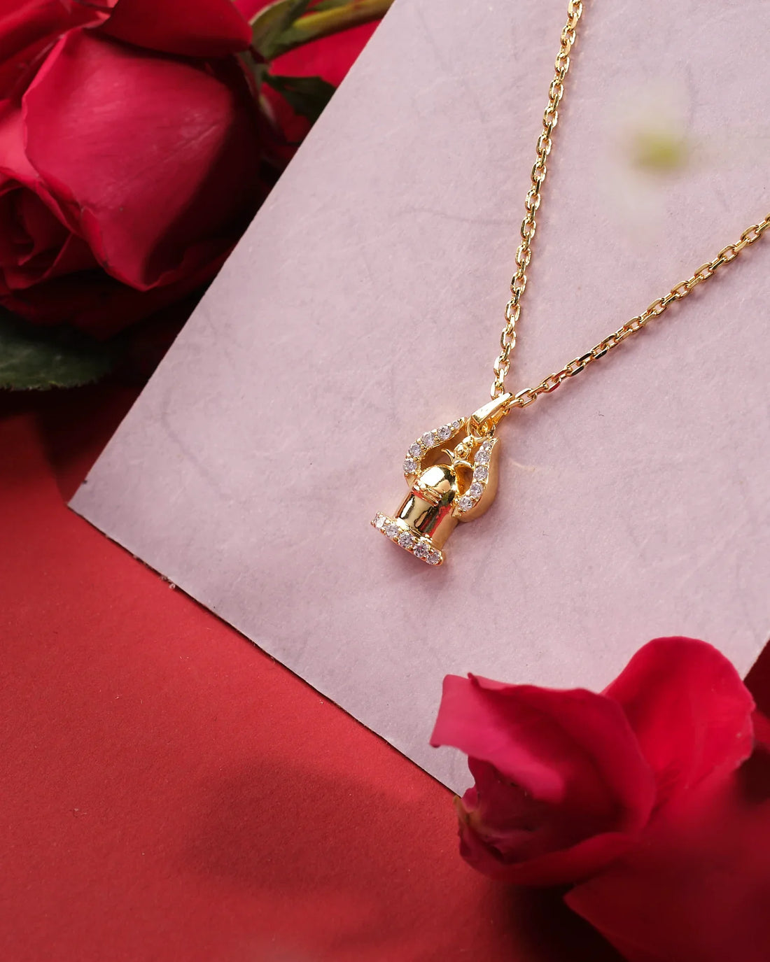 Shiv Om 925 Silver Pendant by Chandrani Pearls India displayed on a white card, surrounded by red roses on a red background, capturing a graceful shine that sparkles.