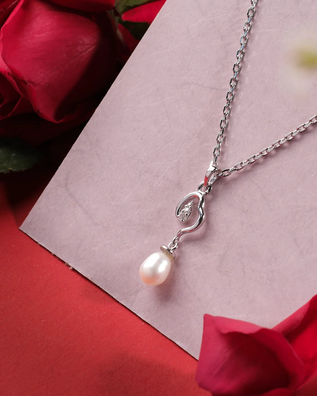 Chandrani Pearls India's Shining String 925 Silver Pendants feature a pearl and crystal accent, elegantly displayed on a light pink card with red roses—ideal for formal or casual occasions.