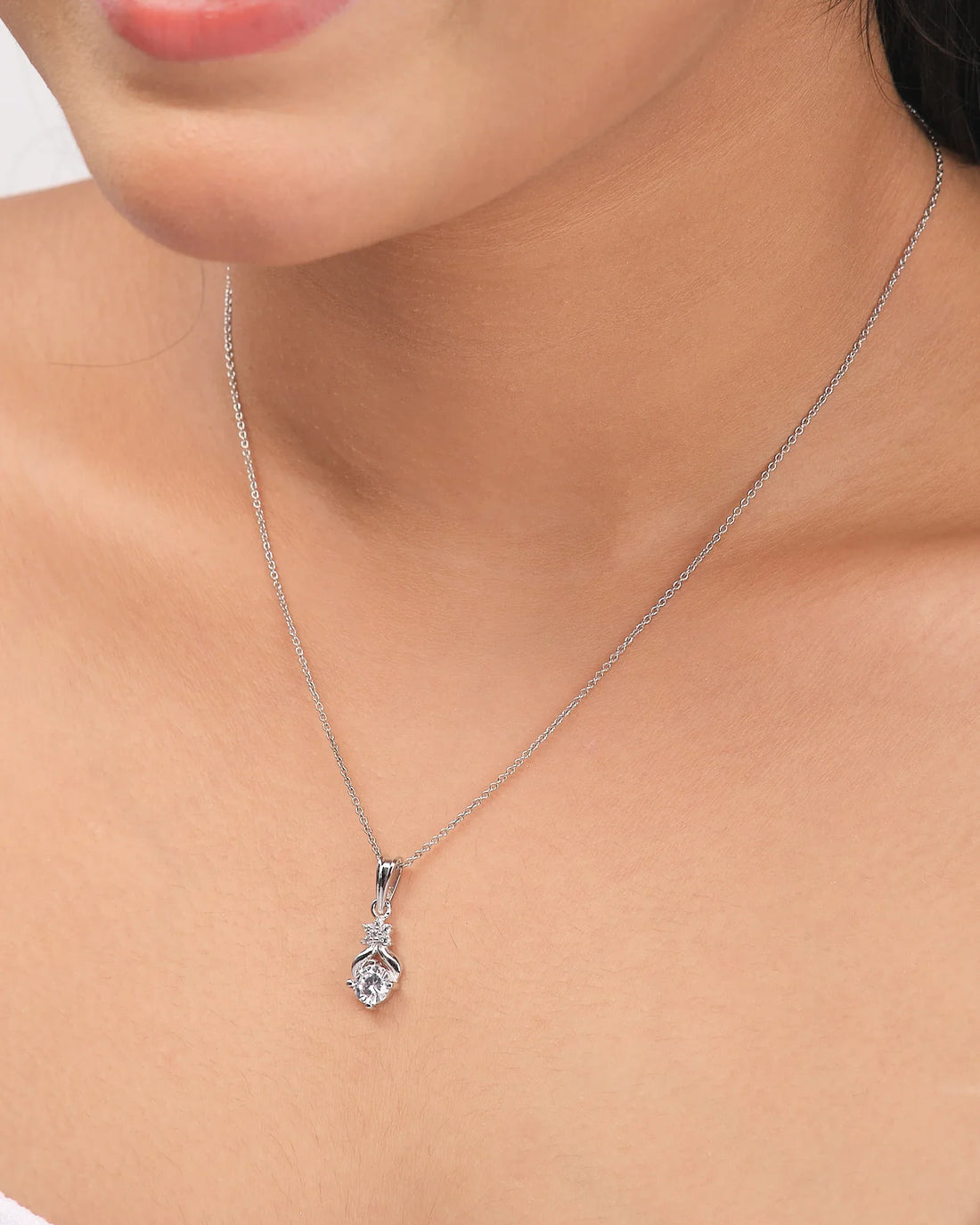 The Chandrani Pearls Classic Demifine Silver Pendant with Dazzling CZ Accent is displayed on a white surface next to a purple ribbon.