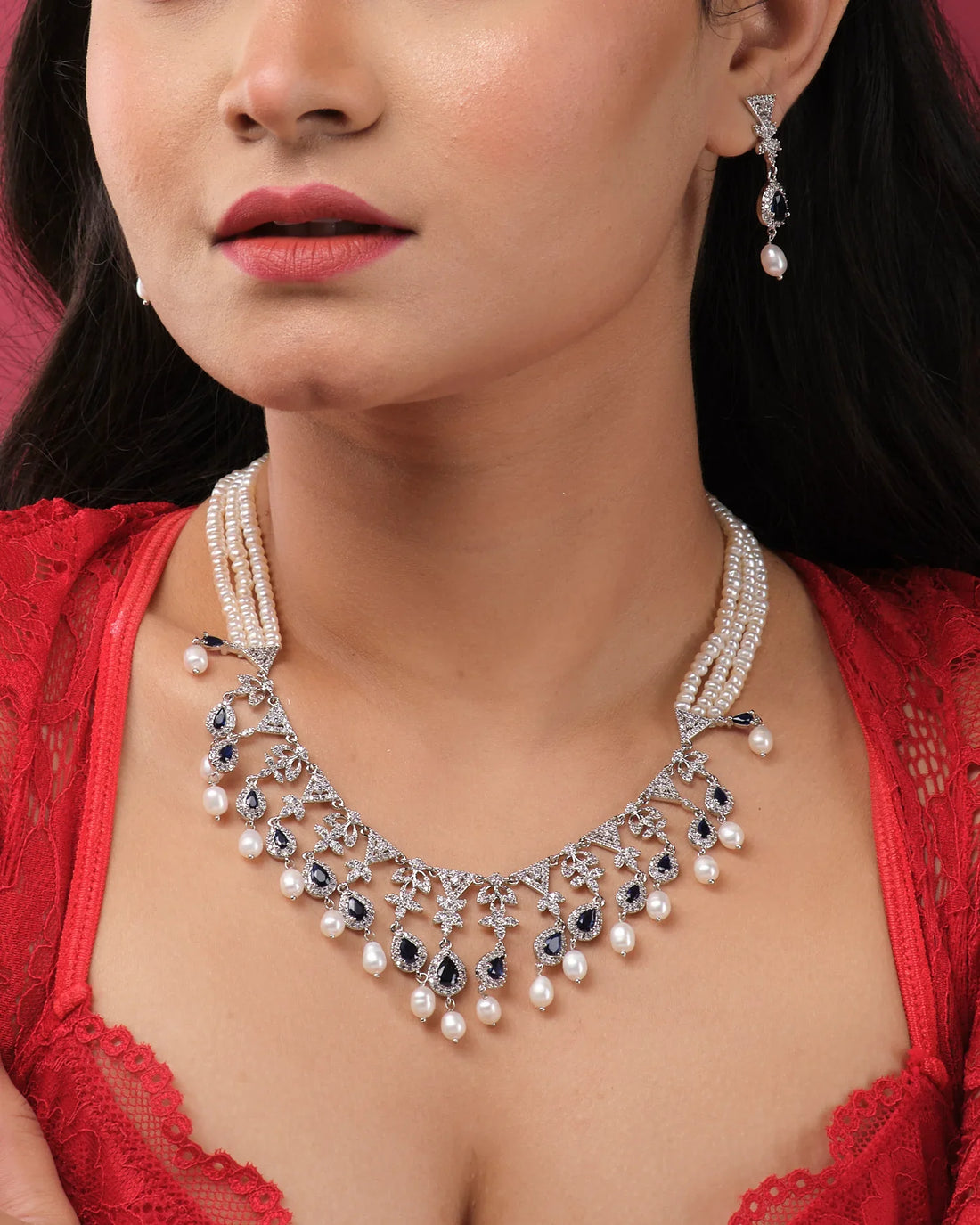 The Trendy Pearl Necklace Set by Chandrani Pearls India exudes elegance and style, featuring a pearl necklace with matching earrings. Displayed on a white jewelry bust, this set stands out beautifully against a blurred background.