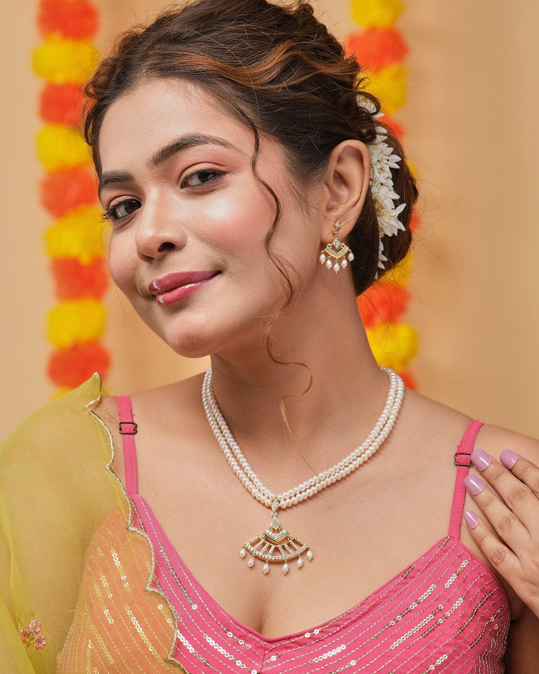 The Eternal Treasure Pearl Necklace Set by Chandrani Pearls, featuring a gold pendant, is displayed on a maroon stand. Matching earrings accompany the set, elegantly presented on a red box.
