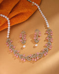 The Chandrani Pearls Petite Pink CZ Pearl Necklace Set Delicate Beauty, shown with matching earrings on beige and orange fabric, is ideal for lovers of elegant minimalist jewelry.