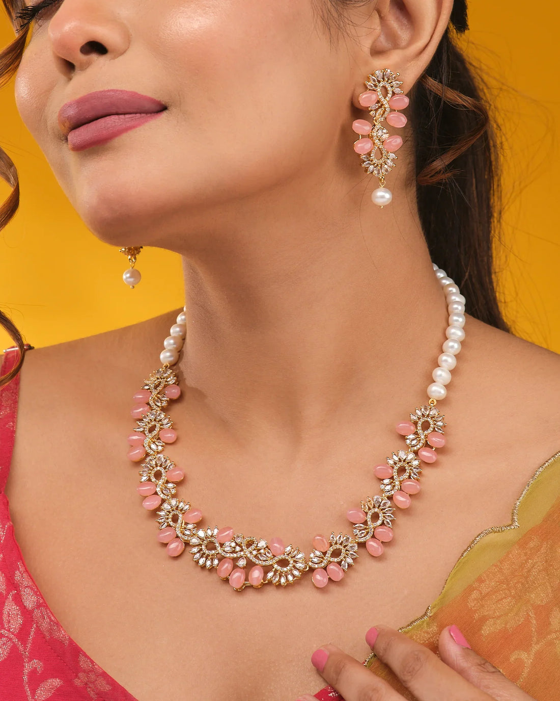 The Chandrani Pearls Petite Pink CZ Pearl Necklace Set Delicate Beauty, shown with matching earrings on beige and orange fabric, is ideal for lovers of elegant minimalist jewelry.