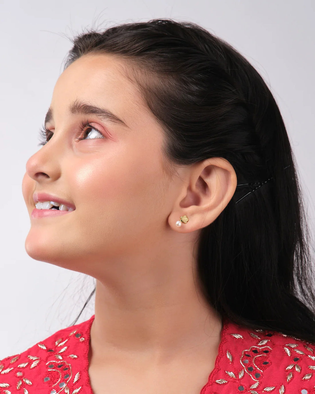 Gold and pearl earrings from Chandrani Pearls India showcased on a star cutout featuring a wizard silhouette.