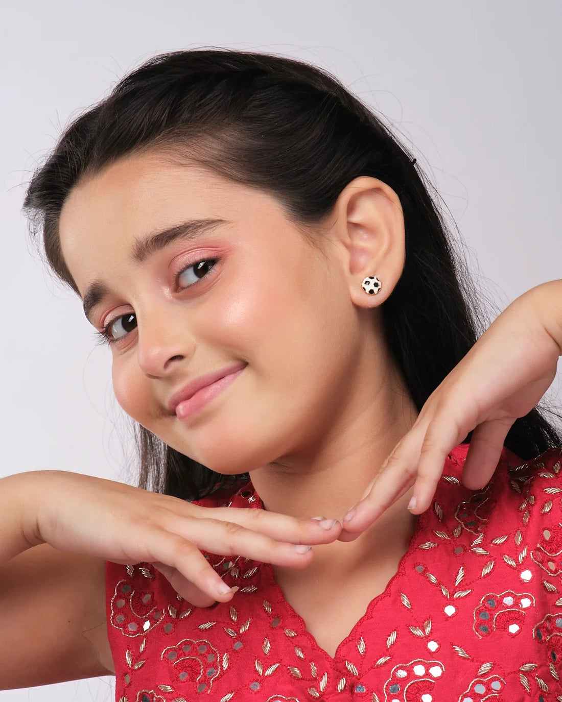Football Style Stud Earrings from Chandrani Pearls India are showcased on a star cutout featuring a silhouette of a figure in a hat pointing a wand.