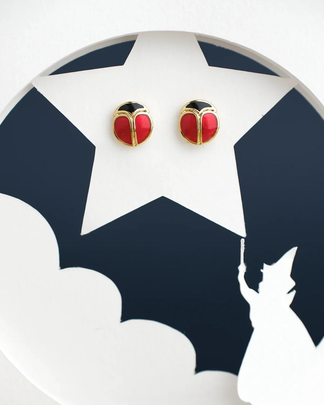 Chandrani Pearls India's Cute Stud Earrings feature a red and black round design on a white star-shaped cutout, complete with a casting figure silhouette at the bottom.