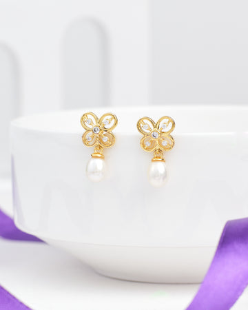 The Regina Butterfly Silver Earrings by Chandrani Pearls, featuring delicate butterfly designs, add elegance and shine to any outfit. Shown on a white bowl rim, they are a simple yet striking accessory choice.