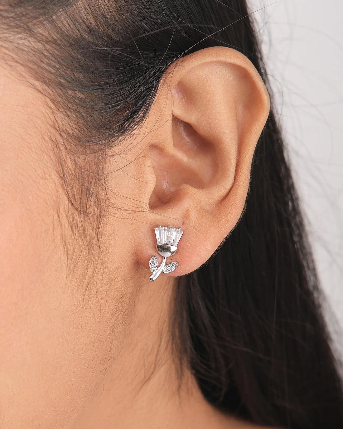 The Brunch Bloom CZ Silver Earrings by Chandrani Pearls feature flower-shaped silver designs with baguette-cut stones and leaf accents—ideal for adding a romantic touch to your casual weekend look.