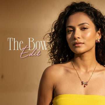 A woman in a yellow top wears a bow-themed necklace and earrings. Text on the image promotes "The Bow Edit" jewellery collection.
