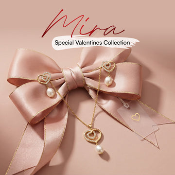 A gold heart-shaped necklace and earrings with pearls are displayed on a pink satin bow. Text reads "Mira The Valentines Collection.