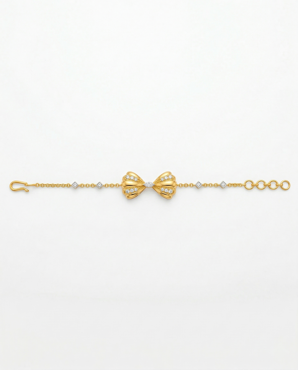 Gold bracelet with bow design on a white background