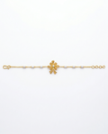 Gold bracelet with a floral clasp on a white background