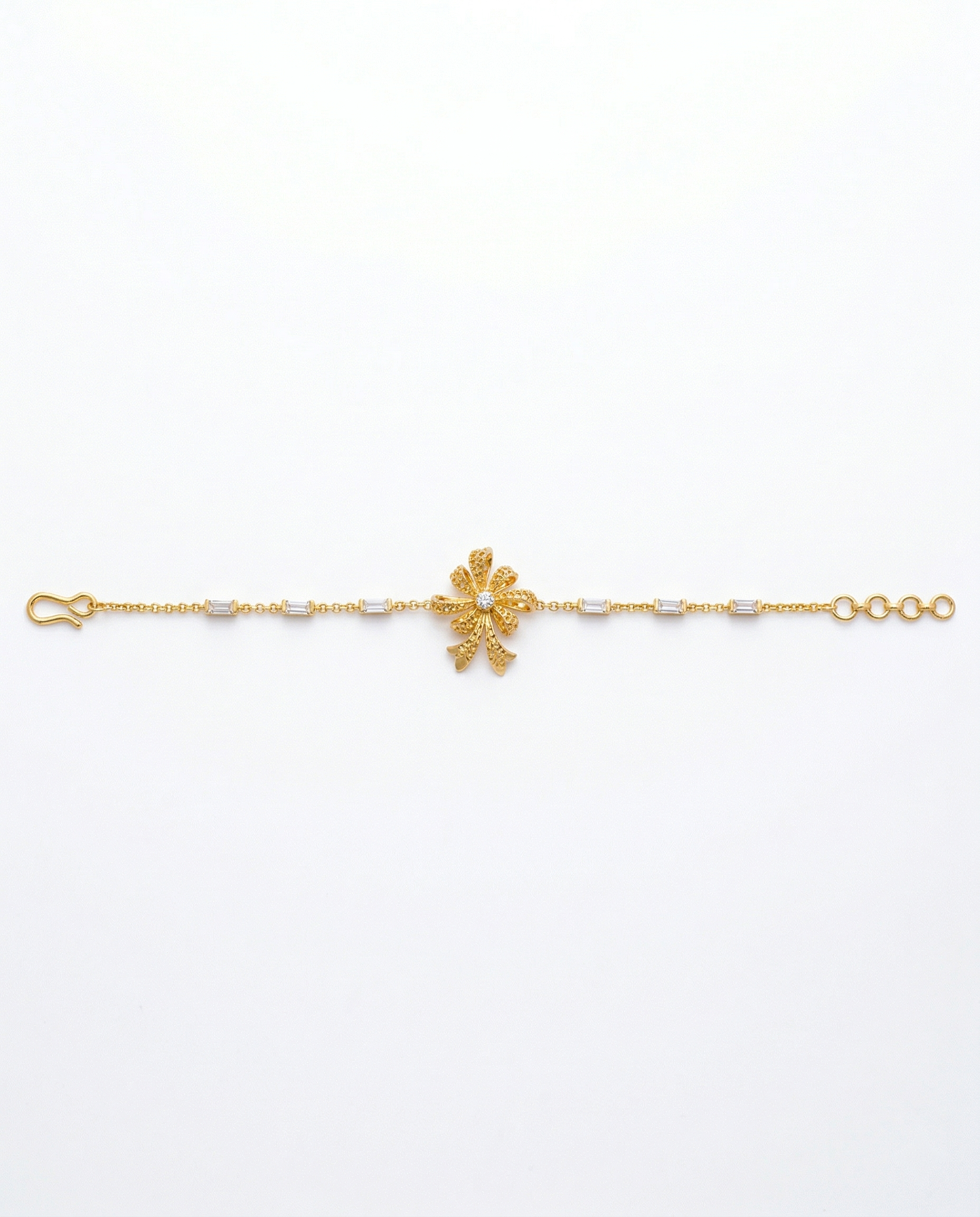 Gold bracelet with a floral clasp on a white background