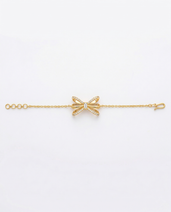 Gold bow-shaped bracelet on a white background