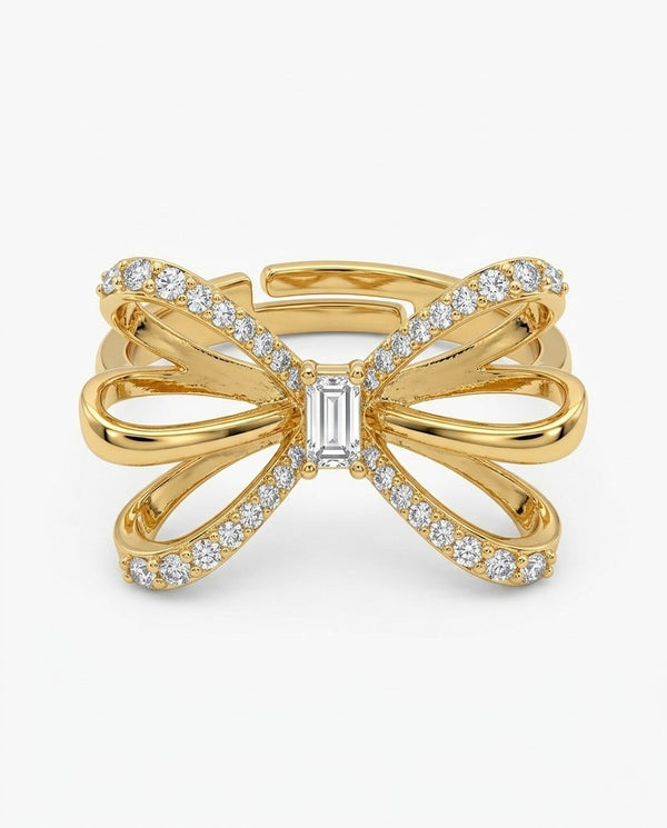 Gold bow-shaped ring with embedded diamonds on a white background