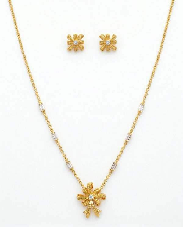 Gold necklace and earrings set on a white background