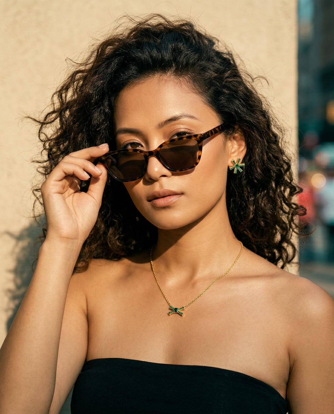 Jewelry set with necklace and earrings featuring green gemstones on a white background