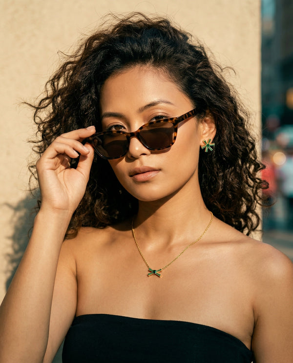 Woman wearing sunglasses with a blurred urban background