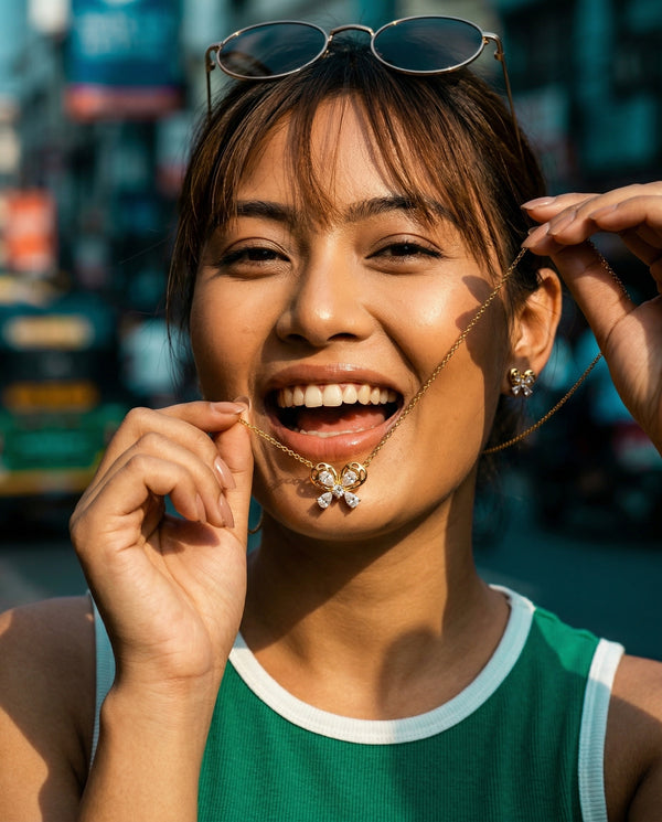 Woman with sunglasses on her head, smiling outdoors with a blurred urban background