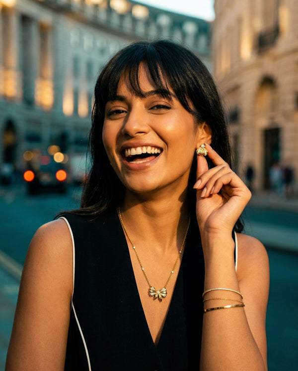 Woman laughing outdoors with a blurred city street background