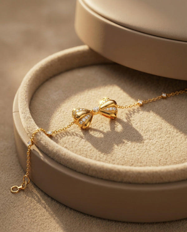 Gold bracelet with bow design on a beige jewelry display