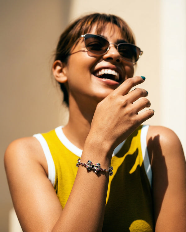 Woman wearing sunglasses and a yellow sleeveless top with a blurred background