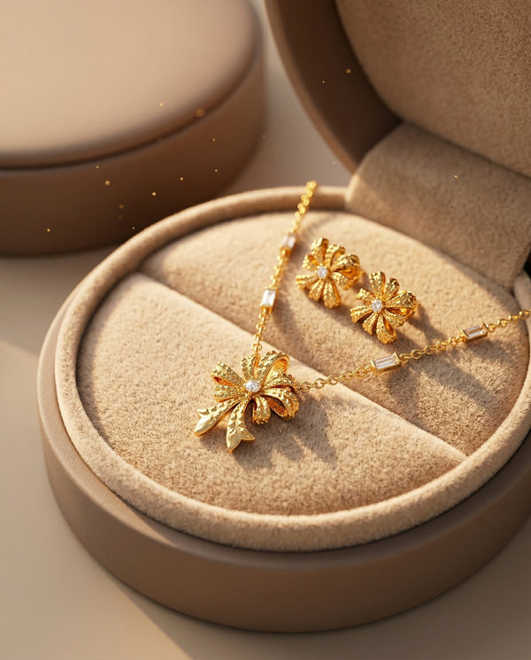 Gold jewelry set with necklace and earrings on a beige cushioned stand.