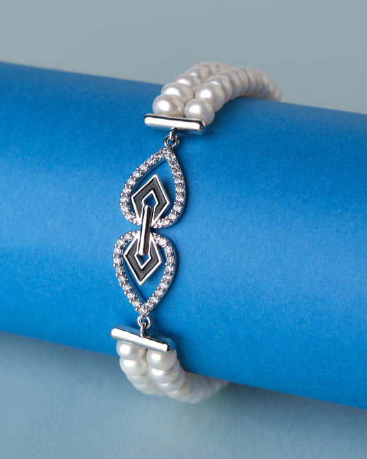 The Chandrani Pearls Modish Stone Studded Pearl Bracelet with diamonds on a blue background.