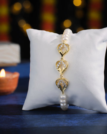 The Nature's Adore Pearl Bracelet by Chandrani Pearls, featuring heart-shaped links and pearl accents, elegantly showcased on a white cushion.