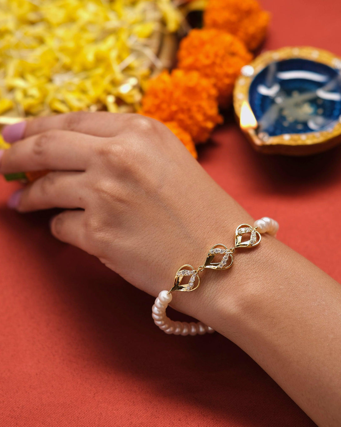 The Nature's Adore Pearl Bracelet by Chandrani Pearls, featuring heart-shaped links and pearl accents, elegantly showcased on a white cushion.