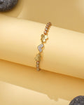 Chandrani Pearls' Elegant Pearl & CZ Tennis Bracelet in Brown Pearl features butterfly charms, some with sparkling crystals, and metallic beads, displayed on a light yellow background.