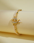 The Beautiful Boat 1 Line Pearl Bracelet by Chandrani Pearls India features pearl accents and a crescent charm with gemstones—an elegant accessory that brings sophisticated shine against a light cream backdrop.