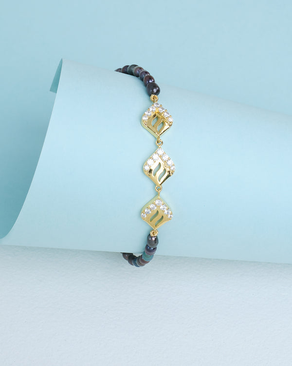 Chandrani Pearls presents "Timeless beauty for any occasion": a gold and stone beaded bracelet with three diamond-studded geometric charms, styled on light blue paper—an elegant piece to elevate your look day or night.
