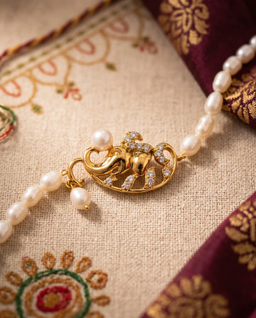 Gold-Plated Lord Ganesha Pearl Rakhi Cum Bracelet