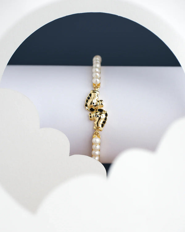 Horse Pearl Bangle for kids by Chandrani Pearls India showcased on a cylindrical stand with a white and dark blue backdrop.