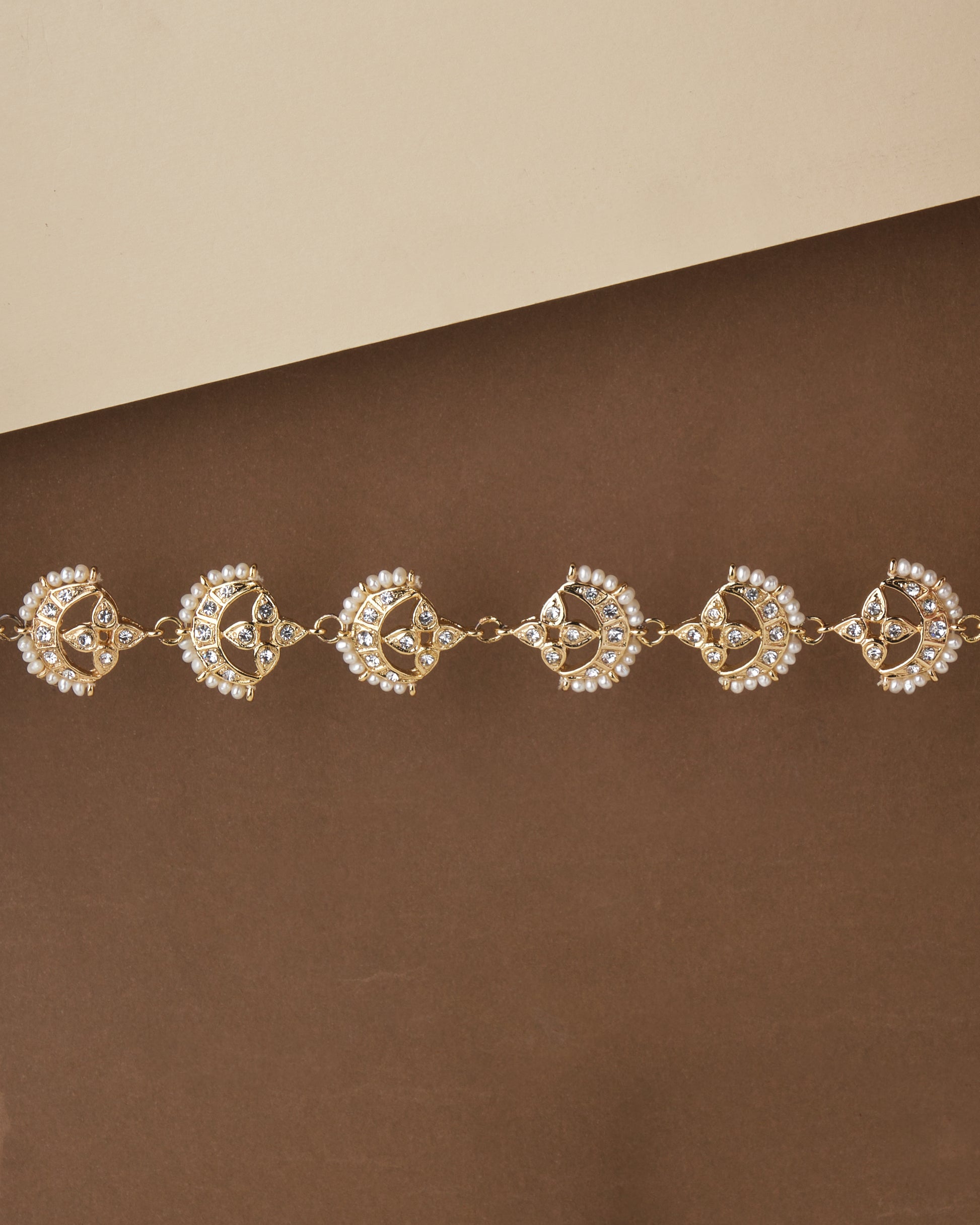 The Nereida Necklet Necklace with pearl accents displayed on a two-tone background by Chandrani Pearls.