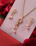 The Trio Threads 925 Silver Pendant Set by Chandrani Pearls India, paired with matching earrings featuring pearl and crystal accents, is displayed on a pink card amid red roses, showcasing refined craftsmanship.