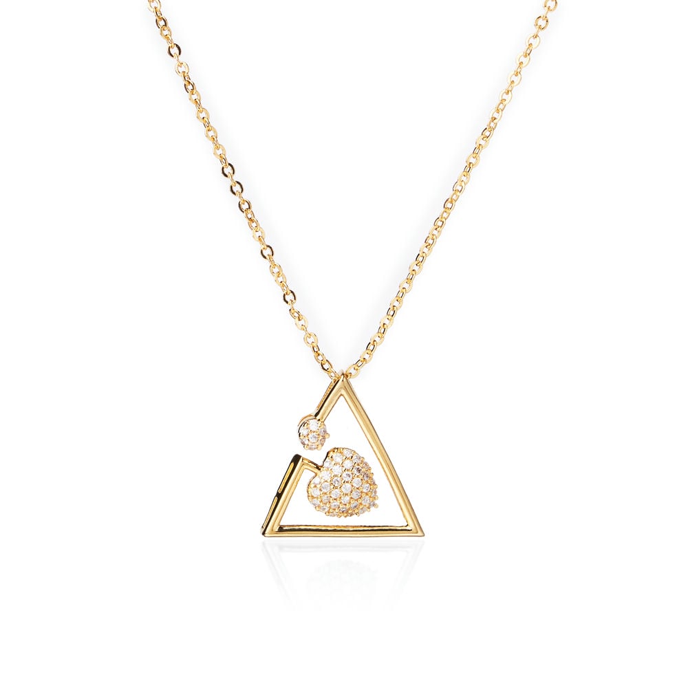 A person in a white blazer wears Chandrani Pearls’ Grateful Heart Pendant—a gold necklace with a triangular motif, symbolizing a mother's love and adorned with small decorative stones.