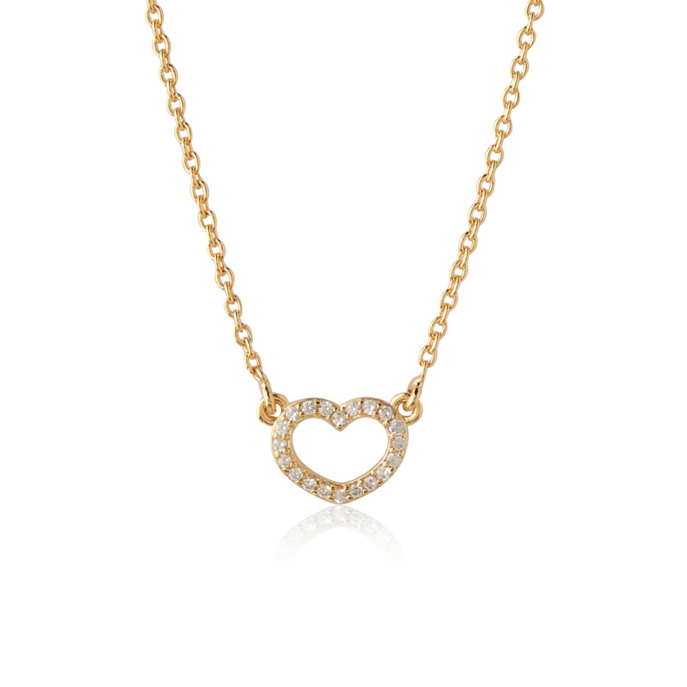 A person wearing a white blazer and the Guardian Heart Pendant by Chandrani Pearls, a gold heart necklace adorned with sparkling cubic zirconia stones.