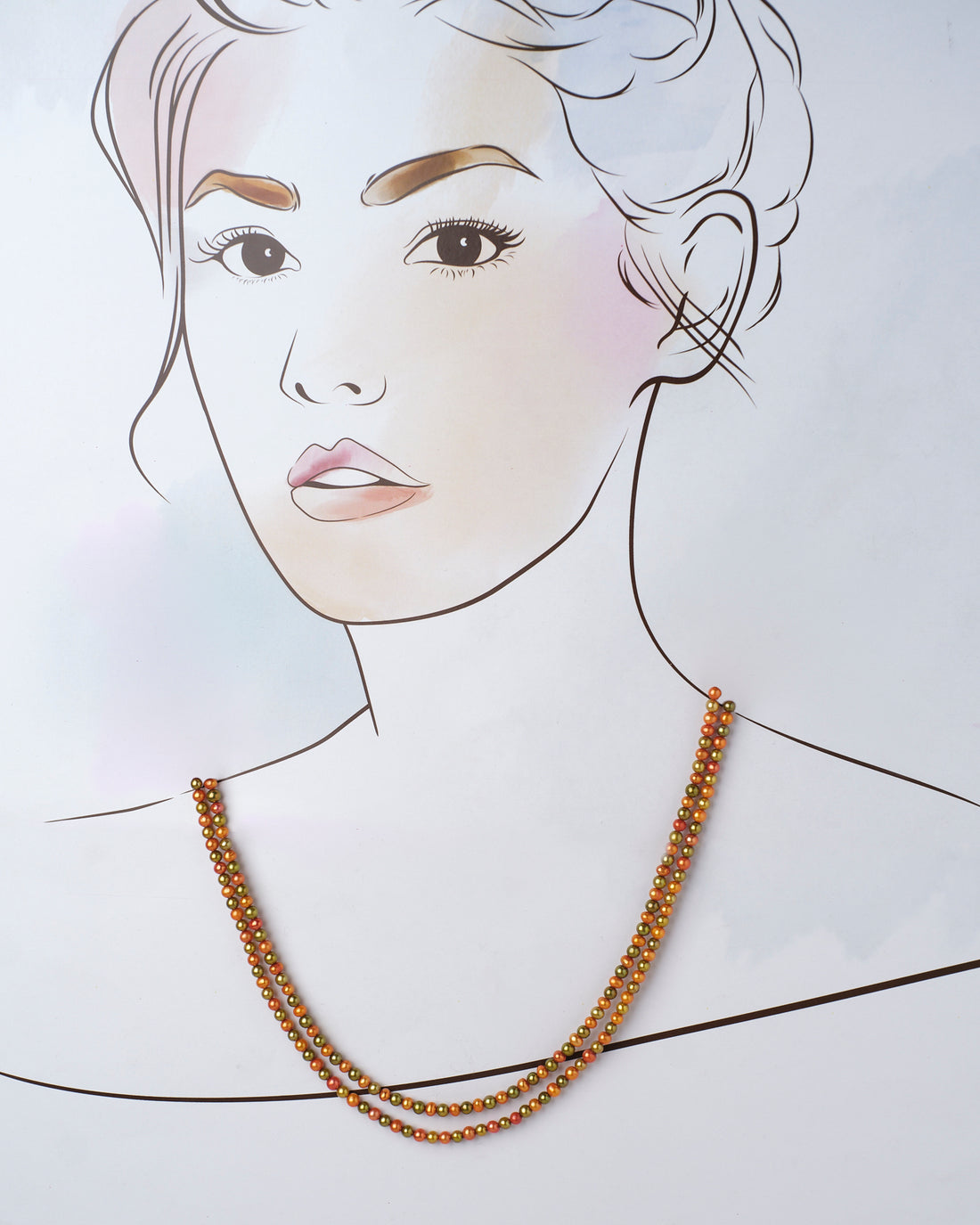 The Hiranya Multi Colour Pearl Necklace by Chandrani Pearls features two lustrous metallic bead strands in gold and copper hues, set against a purple and lavender backdrop with blurred floral details.